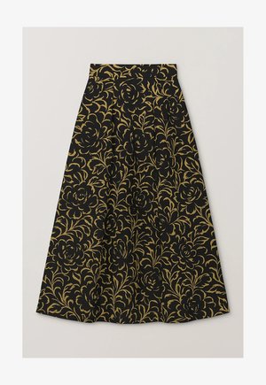 Mustast kangast seelik, millel on kullakarva lillemustrid, kõrge vöökoht, voltide ja voolava A-lõikega siluett. Sile kangapind.