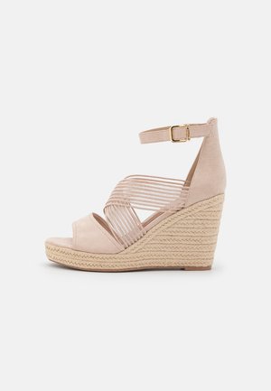 Beige ruskind kilehæl sandal med vævet jutehæl, åben tå, flere krydsede remme og en spændeankelrem for en sikker pasform.