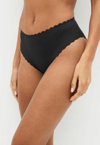 Musthave mustribaga bikiinipüksid, millel on lainelised servad, siledad tekstuur ja puhas disain. Esitatud mudelil neutraalses taustas.