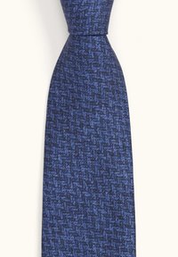 Sininen teksturoitu solmio, jossa on houndstooth-kuvio, valmistettu kudotusta kankaasta ja jossa on kapeneva pää, mikä luo sileän ilmeen.