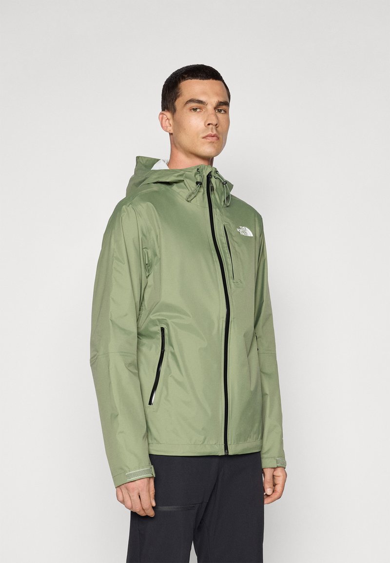 Water-resistant green jacket with a hood, zippered front, and two side pockets. Features a logo on the left chest and elastic cuffs.