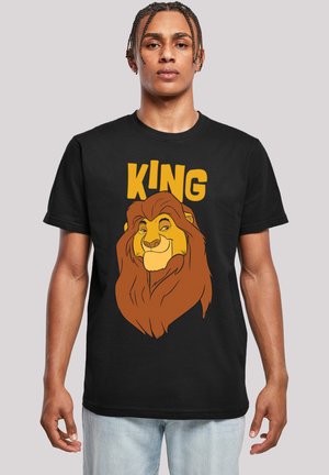 Svart t-skjorte med et grafisk bilde av et løvehode med brunt pels, et gult ansikt, og ordet "KING" i fet gul tekst over.