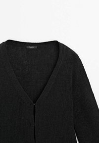 Cardigan noir en tricot avec un col en V profond et des manches longues, motif texturé, et une petite fermeture à l'avant.