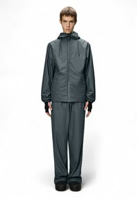 Grijze waterdichte jas met capuchon en verstelbaar trekkoord, gecombineerd met bijpassende broek. De stof is glad en soepel, met handschoenen zonder vingers.