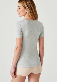 T-shirt grigio aderente con maniche corte, realizzato in morbido tessuto misto cotone, con scollatura rotonda e design senza cuciture sul retro.
