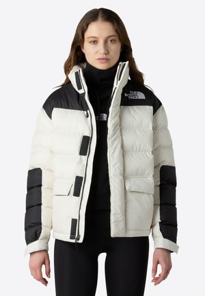 Giacca imbottita in crema e nero, con zip frontale, tasche a patta, polsini a coste e colletto alto; logo sul lato sinistro del petto.