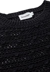 Schwarzer, gestrickter Pullover mit strukturiertem, offenem Gewebe. Verfügt über einen runden Halsausschnitt und ein weißes Markenetikett am Kragen mit Größenangabe.