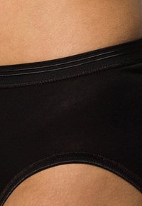 Black brief with a smooth, semi-matte texture, featuring a wide elastic waistband and a cut-out detail on the sides.