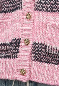 Cardigã de malha rosa com riscas horizontais em azul escuro e branco, com botões decorativos dourados e detalhes em ponto texturizado.