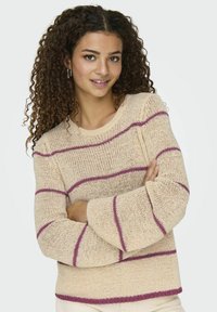Crème trui met losse breistekstuur, voorzien van horizontale roze strepen en belvormige mouwen. Eenvoudige ronde halslijn en een ontspannen pasvorm.