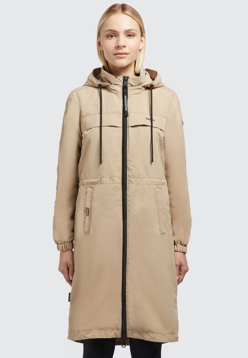 Beige Langjacke mit Kapuze, Frontreißverschluss, zwei Brusttaschen, elastischen Manschetten und glatter Textur. Entwickelt für Wärme und Bequemlichkeit.