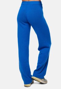 Pantalons en polaire bleue avec une coupe droite et une taille élastique, offrant une texture douce et sans motifs ni accents matériels visibles.