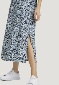 Kukallinen maksimekko tummansinisellä taustalla, valkoisia ja vaaleansinisiä kukkia, sivuaukko, yhdistetty valkoisiin tennareihin. Sujuva kangastunne.