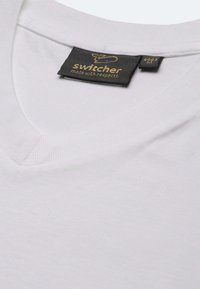 T-shirt bianco a manica corta con scollo a V, realizzato in cotone. Presenta un'etichetta nera con testo dorato che recita "switcher made with respect", cucita sul colletto.