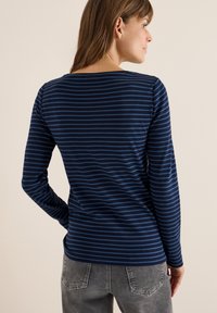 Dunkelblaues Langarmshirt mit feinen horizontalen Streifen in hellblau. Sanfter Stoff, Rundhalsausschnitt und taillierte Passform.