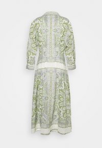Robe à manches longues, longueur mollet, avec des motifs paisley verts et lavande sur fond blanc, vue de dos sur un fond uni.