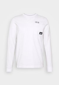 Weißes langärmliges T-Shirt aus Baumwolle mit einer Tasche auf der linken Brust und einem schwarzen Logotag auf der unteren rechten Seite.