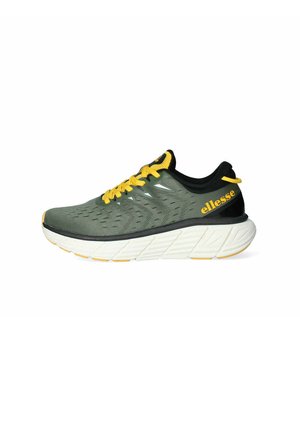 Sneaker da corsa verde con lacci e marchio gialli, dettagli neri, tomaia testurizzata e una spessa intersuola bianca con una suola a disegno.