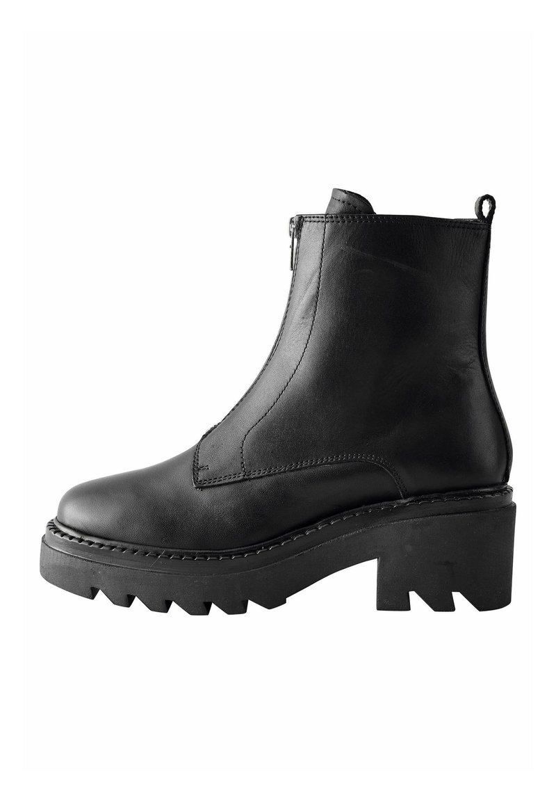Black leather ankle boot with a side zipper, textured design, chunky platform sole, and pronounced tread. Features a pull tab on the back.