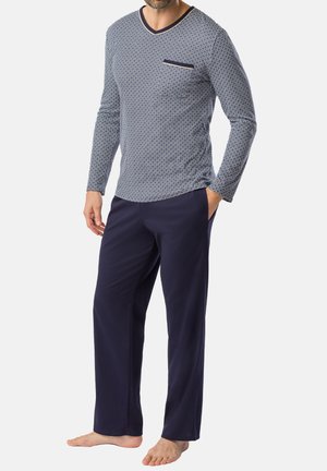 Haut à manches longues bleu marine et blanc à motifs avec une poche, associé à un pantalon bleu marine uni. Tissu doux, coupe décontractée, design minimal.