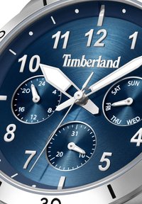Orologio in acciaio inossidabile blu con accenti argentati, dotato di grandi indicatori delle ore, tre quadranti per il giorno e la data, e il logo Timberland.