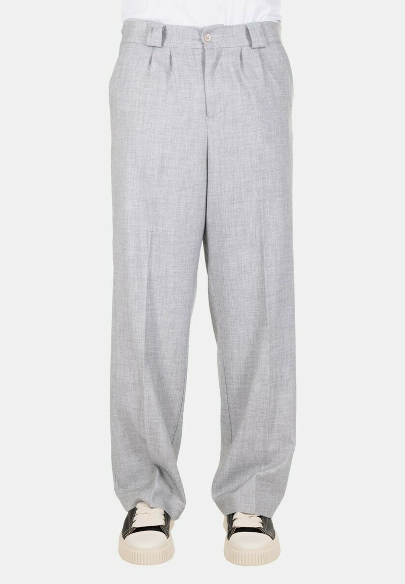 Pantaloni in lino grigi con una vestibilità ampia, presenti di chiusura frontale con bottone, pieghe e tasche. Abbinati a sneakers di colore chiaro.