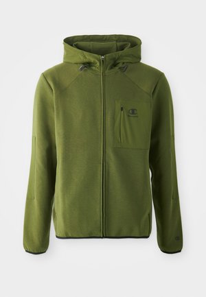 Chaqueta con capucha verde, fabricada en un tejido suave, con cierre de cremallera, bolsillos laterales y un bolsillo en el pecho delantero con un parche de logo.