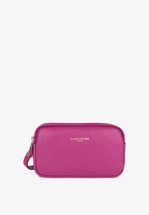 Petite pochette rectangulaire en cuir rose avec fermeture éclair, bracelet de poignet et logo "Lancaster Paris" en lettres dorées sur le devant.