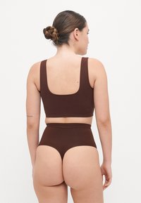 Brown seamless bralette and high-waisted briefs made from soft fabric. The bralette has wide straps and a wide back design.