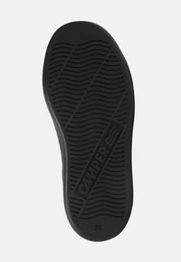 Semelle de chaussure en caoutchouc noir avec un motif ondulé texturé. Comprend le logo "Camper" et la taille "28" embossés à la surface.