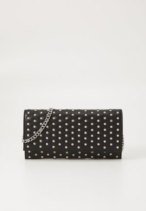 Pochette en cuir noir avec un motif en studs argentés, fermeture à rabat et une chaîne en argent. Texture lisse avec une forme structurée.