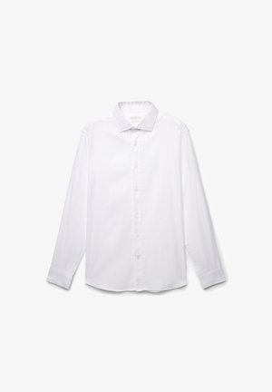Chemise blanche à manches longues, boutonnée, en coton lisse. Elle présente un col classique, des fermetures à boutons et des poignets repliés, sans motifs ni embellissements.
