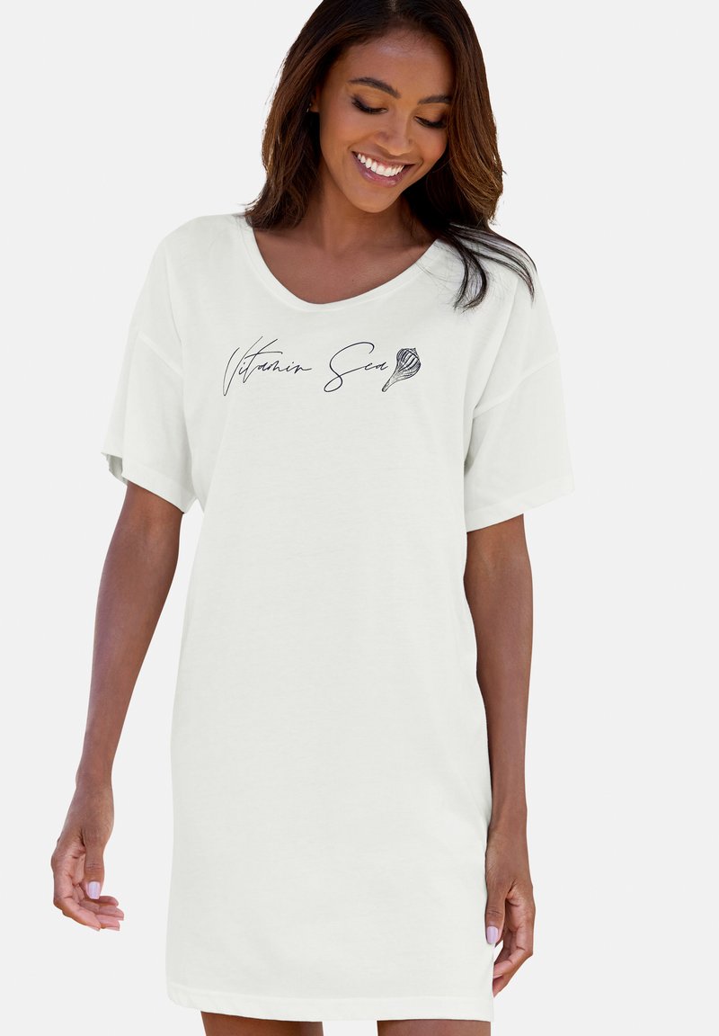 Abito bianco a maniche corte con vestibilità ampia e scollatura rotonda. Sul davanti è presente la scritta "Vitamin Sea" in corsivo nero.