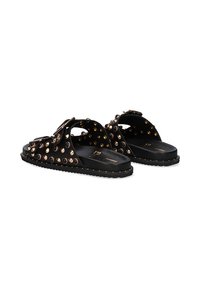 Sandalias deslizantes negras con tachuelas de metal dorado y una superficie texturizada. Diseño abierto con suela plana y forma minimalista.
