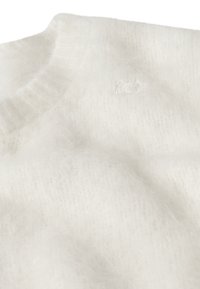 Suéter blanco suave de punto con cuello alto acanalado y sutil detalle bordado de "10" en el pecho.