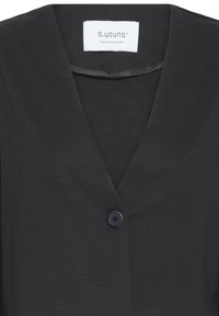 Veste noire à col en V avec un seul bouton noir et une étiquette blanche visible à l'intérieur du col portant l'inscription "b.young THE COLLECTION".