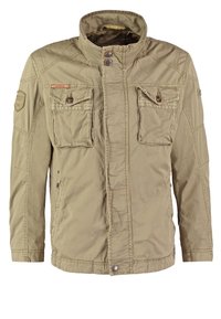 Khaki kurtka z wysokim kołnierzem, dwoma kieszeniami na piersi i zapięciem na napy. Wykonana z lekkiego materiału o miękkiej fakturze i widocznym przeszyciu.