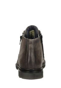 Bruine leren enkellaars met een gladde textuur, zijrits en versterkte hak. Heeft een subtiele glans en een stevige rubberen zool.