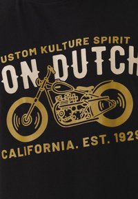 Camiseta negra de algodón con texto gráfico en dorado e ilustración de una motocicleta, con "Spirit de la Cultura Personalizada" y "California. EST. 1929."