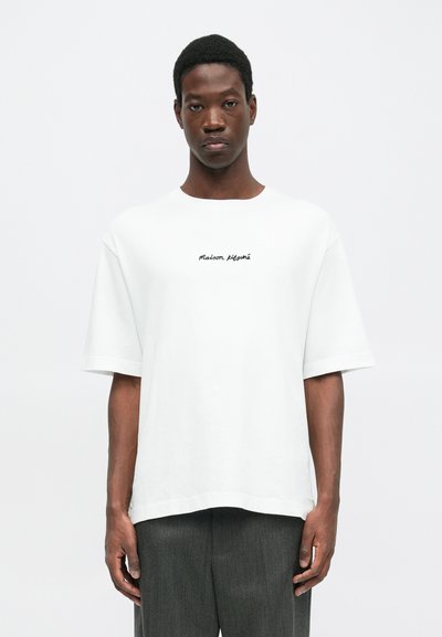 White short-sleeve t-shirt with a loose fit, featuring black embroidered text "Maison Kitsuné" on the chest. Soft cotton fabric.