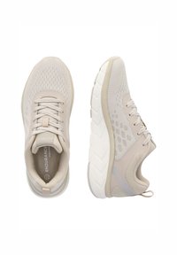 Beiga sportskor med en andningsbar mesh-övre, vadderad krage och en texturerad gummisula med ett zickzackmönster för grepp.