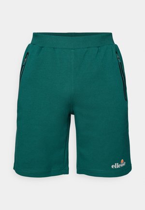 Grønne sportshorts lavet af blødt stof, med en elastisk talje, sidelommer med lynlås og et logo nederst til venstre.
