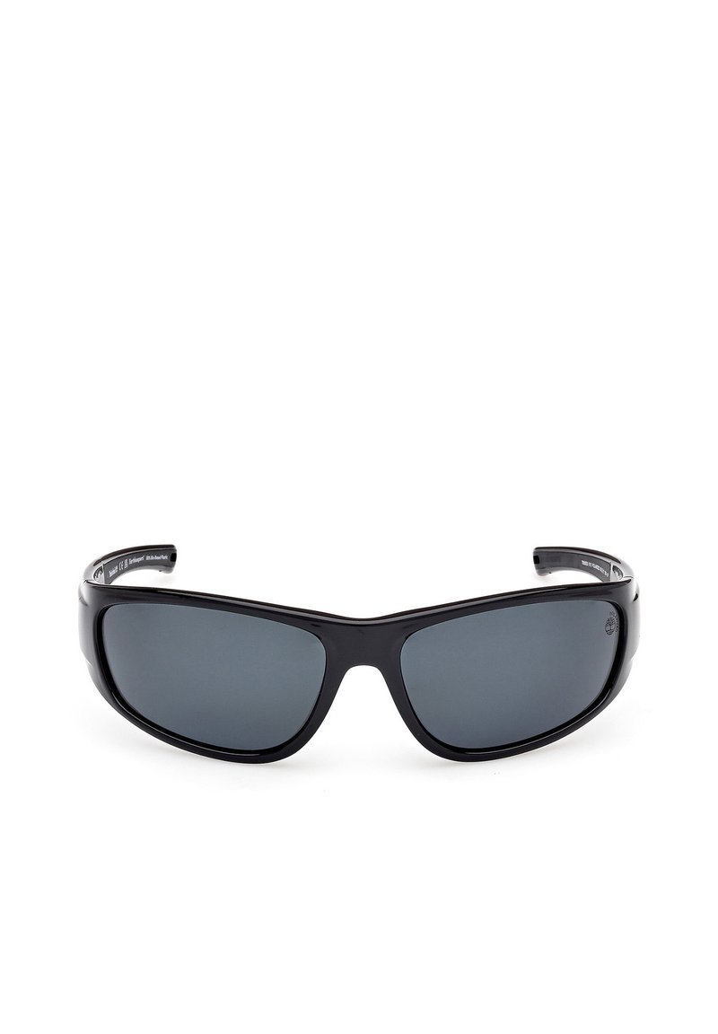 Gafas de sol deportivas negras con lentes gris oscuro, diseño de marco envolvente elegante y brazos texturizados para un mejor agarre. Material plástico ligero y duradero.