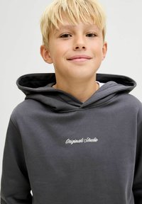 Felpa grigia con cappuccio e coulisse, con testo ricamato "Originals Studio" sul petto. Tessuto morbido e vestibilità rilassata, progettata per il comfort.