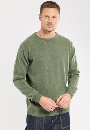 Pull en tricot vert avec un col rond et des poignets côtelés. La texture semble douce et chaude, avec un design simple sans motifs.