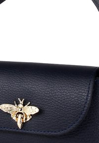 Navy leren handtas met een gestructureerd oppervlak, voorzien van een gouden bijaccent op de klep en een gestructureerd ontwerp met een bovenhandvat.