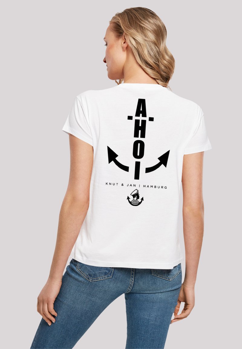 White cotton t-shirt featuring black text "AHOI" and arrows on the back, along with "Knut & Jan | Hamburg" and a sailor icon.