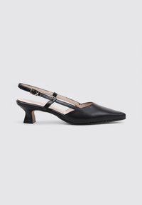 Chaussure slingback en cuir noir avec un bout pointu, un petit talon carré et une fine sangle de cheville ornée d'une boucle. Texture lisse, design minimaliste.