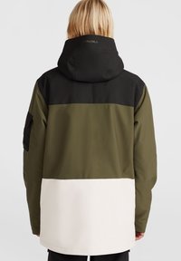 Grøn og sort vandtæt jakke med en hvid nederste sektion, lynlåslommer og justerbar hætte; glat tekstur med farveblokering design.