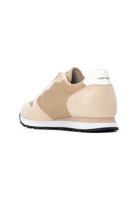 Sneaker in suede beige con pannello laterale in tessuto color tan, accentuazione bianca sul tallone, suola in gomma nera e lacci bianchi a contrasto.
